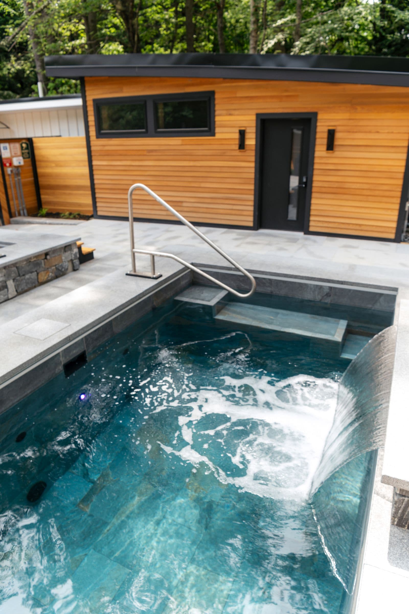 Modern houten poolhouse naast een zwembad